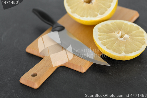 Image of close up of lemon and knife on cutting board