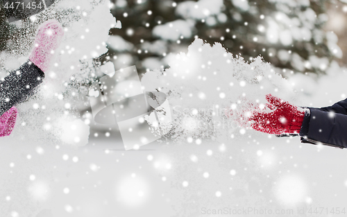 Image of happy friends playing with snow in winter