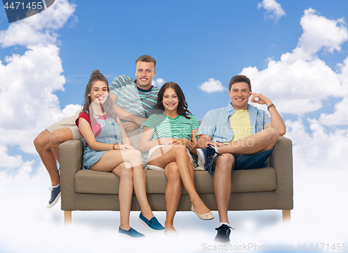 Image of friends sitting on sofa over sky and clouds