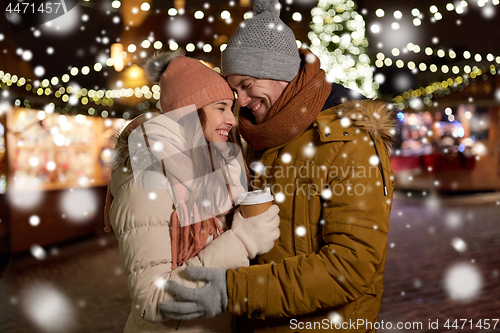 Image of happy young couple with coffee at christmas market