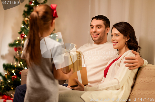 Image of happy family with christmas present at home