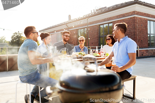 Image of happy friends at barbecue party on rooftop