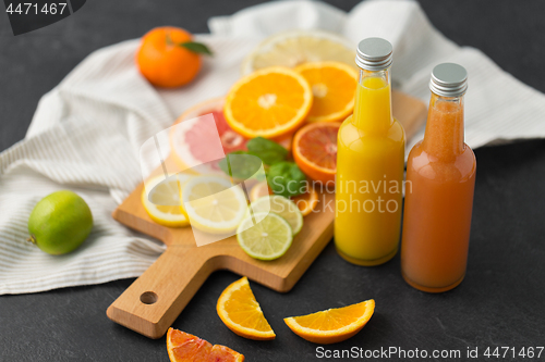 Image of glass bottles of fruit juice on slate table top