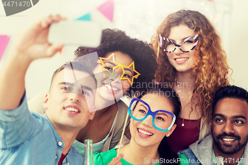 Image of happy team taking selfie at office party