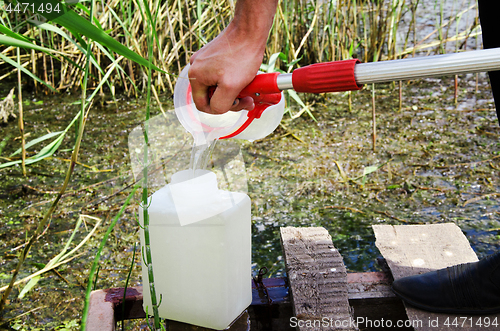 Image of Take samples of water for laboratory testing. The concept - analysis of water purity, environment, ecology.