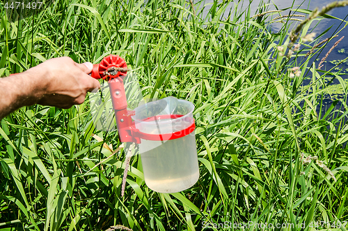 Image of Take samples of water for laboratory testing. The concept - analysis of water purity, environment, ecology.