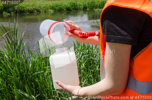 Image of Take samples of water for laboratory testing. The concept - analysis of water purity, environment, ecology.