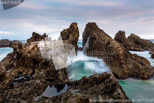 Image of Ocean waves pushing through the dramatic jagged rock gap channel