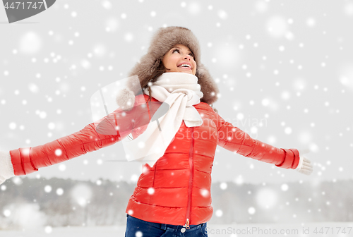 Image of happy woman in winter fur hat outdoors