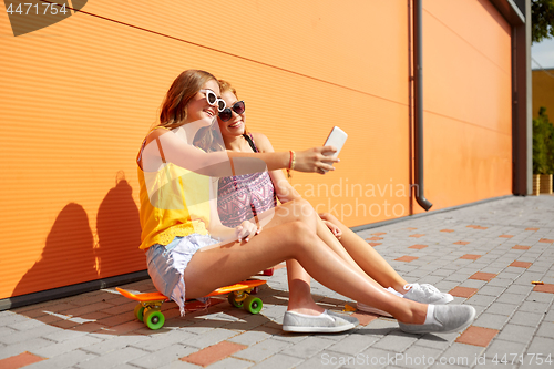 Image of teenage girls with skateboards taking selfie