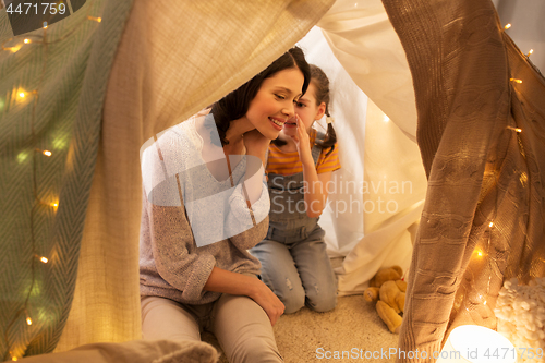 Image of happy family whispering in kids tent at home