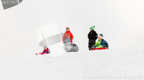 Image of little kids sliding on sleds down hill in winter