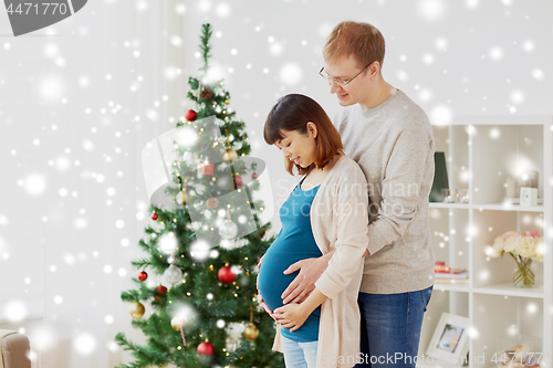 Image of pregnant wife with husband at home at christmas