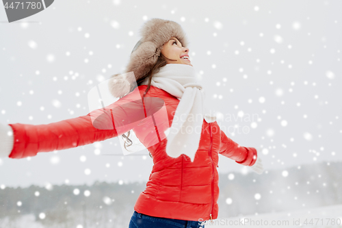 Image of happy woman in winter fur hat outdoors