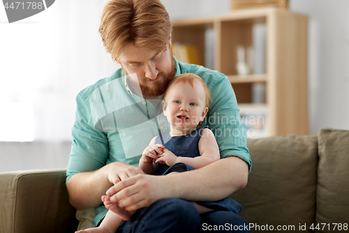 Image of happy father with little baby daughter at home