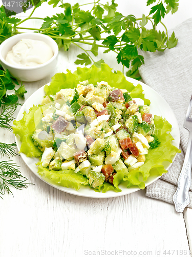 Image of Salad of salmon and avocado on light wooden board