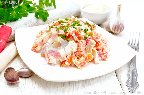 Image of Salad of surimi and tomatoes with mayonnaise on table