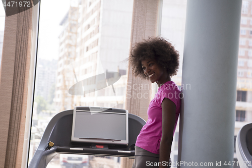 Image of afro american woman running on a treadmill