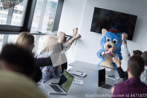 Image of boss dresed as bear having fun with business people in trendy of