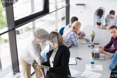 Image of Two Business People Working With Tablet in office