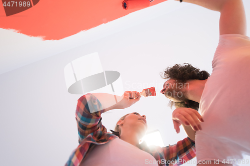 Image of couple painting interior wall