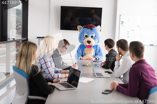 Image of boss dresed as bear having fun with business people in trendy of