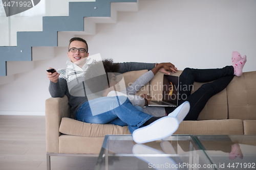 Image of multiethnic couple relaxing at home