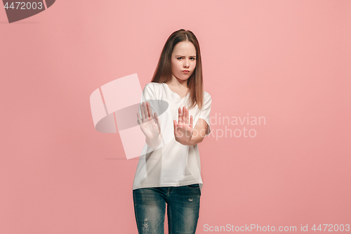 Image of Doubtful pensive teen girl rejecting something against pink background