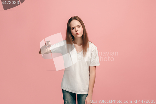 Image of The happy teen girl pointing to you, half length closeup portrait on pink background.