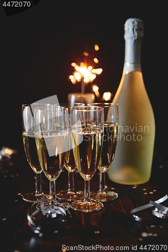 Image of Party composition image. Glasses filled with champagne placed on black table
