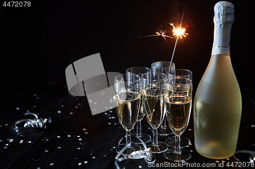 Image of Party composition image. Glasses filled with champagne placed on black table