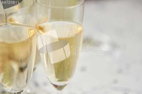 Image of Champagne glasses and bottle placed on white marble background