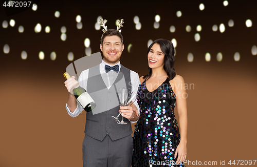 Image of couple with champagne bottle at christmas party