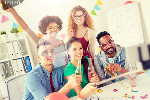 Image of happy team taking selfie at office party