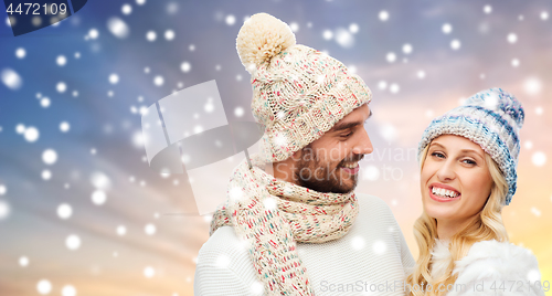 Image of happy couple in winter clothes over snow