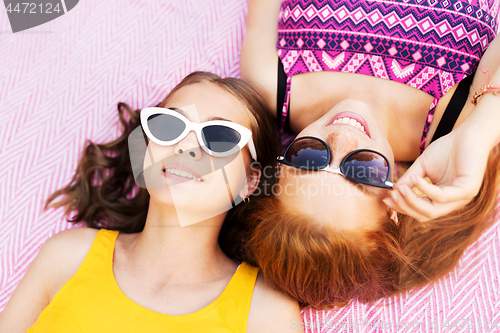 Image of teenage girls in sunglasses on picnic blanket