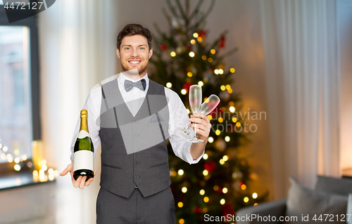 Image of man with bottle of champagne and glasses at party