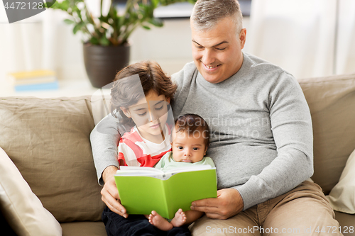 Image of happy father with sons reading book at home