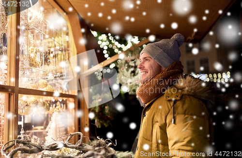 Image of happy man looking at christmas market shop window