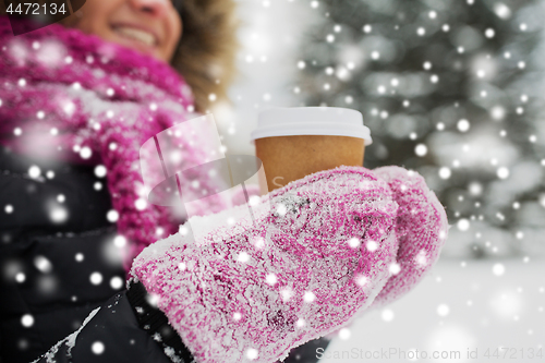 Image of close up of hand with coffee outdoors in winter