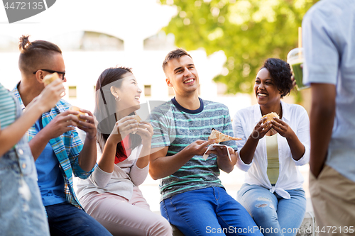 Image of friends eating pizza and sandwiches in park