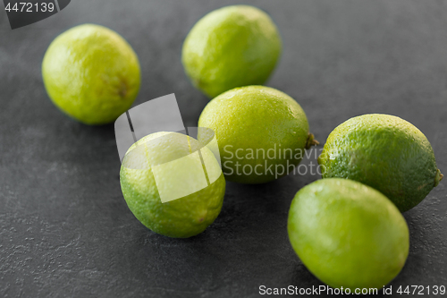 Image of close up of whole limes on slate table top