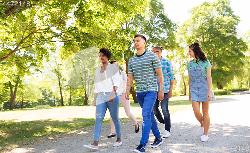 Image of happy international friends walking in park