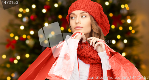 Image of woman with shopping bags over christmas lights