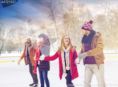 Image of happy friends on skating rink outdoors