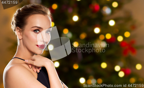 Image of beautiful woman over christmas tree lights