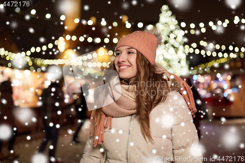 Image of happy young woman at christmas market in winter