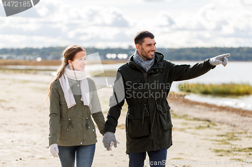 Image of couple walking along autumn beach