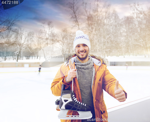 Image of happy young man showing thumbs up on skating rink
