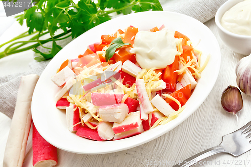 Image of Salad of surimi and tomatoes on wooden board